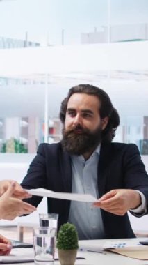Dikey video finans danışmanı müşterilere bütçe yönetimi ile ilgili bilgilendirici broşürler sağlıyor. Ofisteki danışman aile üyelerine yatırım hesapları oluşturmalarında yardım ediyor, kamera A