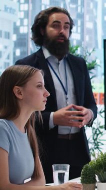 Ofisteki dikey video komisyoncusu müşterilerine finansal tavsiyeler sunuyor, büyük ekrandaki forx indeks değerlerine bakıyor. Mali danışman ailenin ekonomik kararlar almasına yardım ediyor, pazarı analiz ediyor.