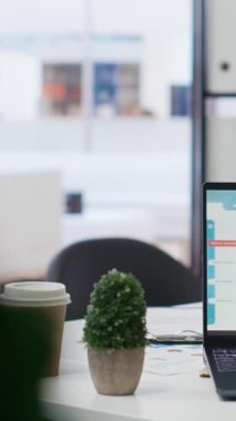 Kurumsal ofis masasında bulunan dikey video dizüstü bilgisayar cihazı uçucu borsa fiyatlarının yükseldiğini ve düştüğünü gösteriyor. Önx ticaret platformları indeksleri aygıt ekranında olan komisyon firması