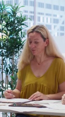 Vertical Video Finans Danışmanı müşterileri gelecekteki yatırımlarını yöneten resmi anlaşma belgelerini imzalamaya davet ediyor. Müşteriler kontrat imzalarken mal varlıklarına el koymayı kabul ediyorlar.