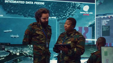 Çeşitli ordu subayları düşman hatlarından gelen önemli bilgileri gözden geçirip bir askeri komuta merkezinde avantaj sağlıyor. Güç üssünde uydu görüntülerini kullanan insanlar. Kamera A.