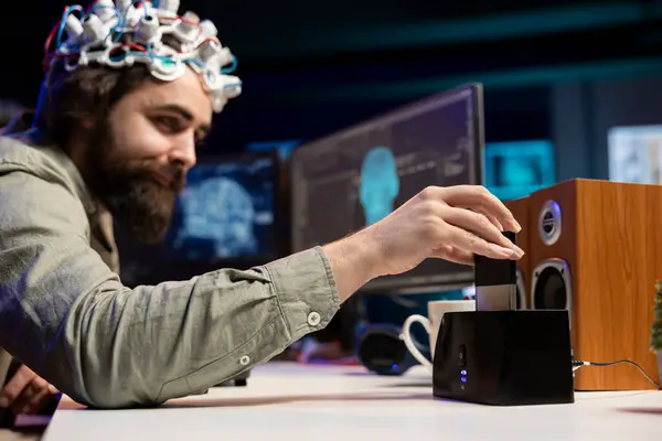 stock image Engineer with EEG headset inserting cartridge into PC to use high tech software allowing for brain transfer into virtual world. Man putting disk in computer to start consciousness upload