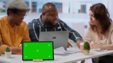 Müşteriler emlakçıyla, tablet üzerindeki izole edilmiş fotokopi alanının yanında görüşüyor, yeni yüksek sınıf ofis alanının planlarını ve planlarını inceliyor. Finansörle emlağa yatırım yapan iş adamları. Kamera B.