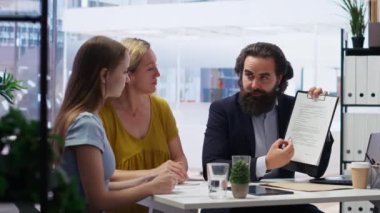 Mali müşavir müşterilerle mali danışmanlık yapmak için toplanıyor ve konforlu gelir elde etmek için adımlar listesi yapıyor. Menajerin müşteriler için bütçe oluşturması, yatırım tavsiyesi vermesi, kamera B