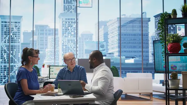 stock image Mature couple engaged in a serious discussion with a financial banker about retirement planning, focusing on optimizing savings, pension plans and financial security. Life insurance. Camera B.