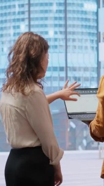 Bir emlak yatırım stratejisini göz önünde bulundurarak, üst sınıf bir ofis için mimari planları gözden geçiren dikey Video İş Geliştirme ekibi. Yöneticiler bir ofis sırasında emlakçıyla pazarlık ediyor.