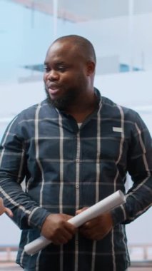 Dikey Video Emlakçısı ve işletme girişimcisi üst sınıf bir iş yerinin planlarını inceliyor, ofis turu sırasında kira sözleşmesi yapıyor. Müşteri arayışı yeni bir ofis alanı, yatırım planlaması