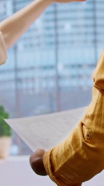 Vertical Video Emlakçısı ve müşterileri ofis turunda iş alanı tasarım vizyonunu paylaşıyor, üst sınıf kentsel ortama geçmeden önce modern emlak düzeni ve planlarını değerlendiriyorlar. Kira sözleşmesi