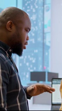 Vertical Video Emlakçısı ve iş ekibi çalışma alanı tasarımı ve taşınmayı değerlendiriyor, ofis turu sırasında planları gözden geçiriyorlar. Başlangıç gelişimi için emlak yatırımı. Kontrat anlaşması