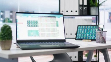 Yatırım tahvilleri ve diğer mali varlıkların toplandığı cihazlar üzerine hisse senedi portföyü olan boş bir ofis. Dizüstü bilgisayar ve tablette hisse senedi talep artışını gösteren gerçek zamanlı indeks göstergeleri