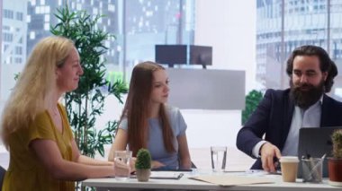 Finansal danışman müşterilere finansal stratejiler sunuyor, borsa tahvilleri öneriyor. Ofiste komisyoncu ön x yatırım portföy yönetimi, kamera B ile müşterilere yardım ediyor