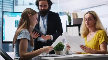 Geleceğe dönük tasarruf alışkanlıkları oluşturmalarına yardımcı olacak bir plan oluşturmak için müşterilerin gelirlerini denetleyen mali danışman. Ajan, ebeveyn ve Z jenerasyonundaki kızla konuşuyor. Yatırım konusunda tavsiye veriyor. Kamera A.