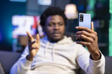 İnternetteki video konferans toplantısında yakın arkadaşınla konuşmak için kullandığın akıllı telefon. Bulanık arkaplandaki kişi tarafından kullanılan telefona odaklan ve video çağrısında arkadaşınla eğlenerek vakit geçir