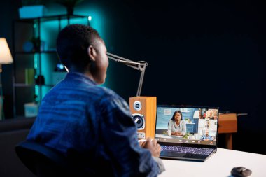 Siyahi bir kadın dijital bir dizüstü bilgisayardan iş arkadaşlarıyla görüntülü görüşme yapıyor. Portatif bilgisayarla Afrika kökenli Amerikalı serbest çalışan bir kadın olarak konferans toplantılarına katılıyor..