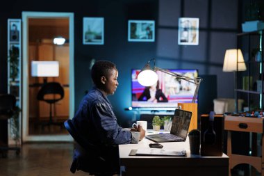 Afrika kökenli Amerikalı kadın serbest çalışan, kişisel bir bilgisayardan konferans görüşmelerine katılan. Siyahi bir kadın dijital dizüstü bilgisayar kullanarak bir video görüşmesinde iş arkadaşlarıyla konuşuyor..