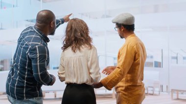 Emlakçı müşterilerine ofis avında rehberlik ediyor planlar, modern mimari planlar ve potansiyel emlak yatırımlarını tartışıyor. Birinci sınıf bir şehir ortamında yeniden yerleştirme. Kamera B.