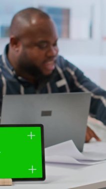 Dikey Video İstemcileri, tablet üzerinde izole edilmiş kopya alanının yanında emlakçıyla görüşüyor, yeni yüksek sınıf ofis alanının planlarını ve planlarını inceliyor. Mülke yatırım yapan iş adamları