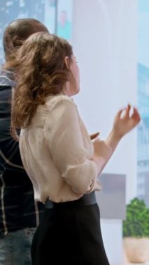 Vertical Video Skills emlakçısı bir ofis turu için iş adamlarını karşılıyor, yüksek sınıf bir binadaki yeni şirket çalışma alanını inceliyor. Gayrimenkul yatırımının geliştirilmesi