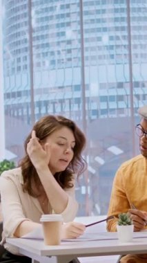 Dikey Video İstemcisi ve emlakçı, emlak planının mimari planlarını inceliyor, bir ofis turunun sonunda yatırım fırsatlarını değerlendiriyor. Bir toplantı sırasında planlar üzerinde çalışmak