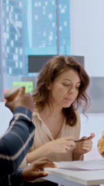 Bir ofis turunda bir emlak komisyoncusuyla düşey video girişimcisi buluşması, müşteriye üst sınıf işyerinde rehberlik etmek ve mimari planlar ve planlar sunmak. İş dünyası