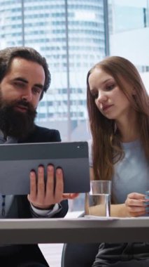 Yatırım hesapları oluşturmada müşterilere yardım eden, denetleme yapan dikey video finans danışmanı. Aileye yardım etmek için tablet üzerinde finansal planlama yazılımı kullanan danışman, kamera A