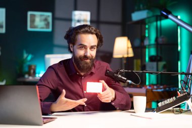 Gülümseyen teknoloji gurusunun portresi. Mini ışık değerlendirmesi. Seyirciler için açılması. Neşeli internet yıldızı abonelere film ekipmanları gösteriyor, mikrofonla konuşuyor.