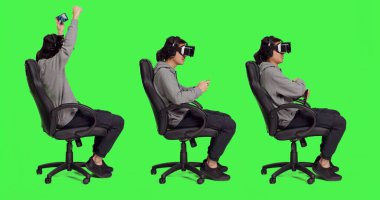 Stüdyoda, Asyalı yetişkin VR başlıklı telefon oyunlarından hoşlanır, gözlüklü mobil yazılımla çevrimiçi rol yapma oyununa katılır. Genç oyuncu sanal gerçeklikle eğleniyor..