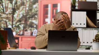 Evdeki bir yazılımın muhasebe veri raporlarını inceleyen girişimci, istatistiklerle kaynak tahsisi üzerinde çalışırken hayal kırıklığına uğramış hissediyor. Danışman stratejik hedeflere ulaşmakta başarısız. Kamera A.