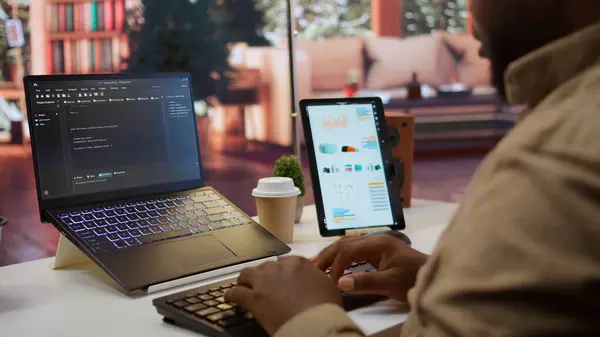 stock image AI software developer creating an algorithm for deep learning and data mining, coding on his laptop at home office. Expert processing binary code on supercomputer neural network. Camera B.