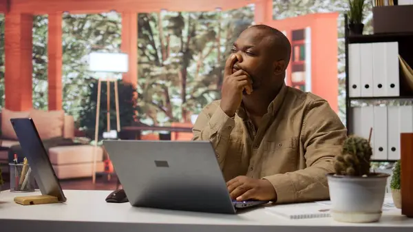 stock image Entrepreneur thinking of a new strategy to obtain more funds and expand the business, increase profit and sales. Financial audits and budget planning on a laptop, telecommuting. Camera B.