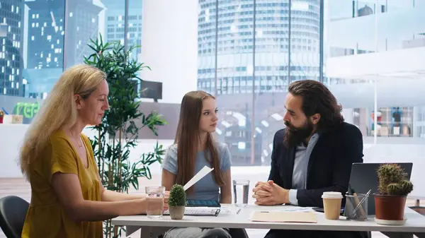 stock image Financial advisor assessing clients economic goals to provide personalized planning guide during office meeting. Agent optimizing investment returns for mother and daughter requesting help, camera A