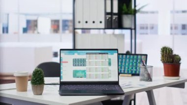 Borsa verileri ve istatistikleri gösteren dizüstü bilgisayar ve tabletin yer aldığı finans analisti çalışma alanı. Ofisteki cihazlar, önx ticaret analitik rakamlarıyla evrak işlerinin yanında.