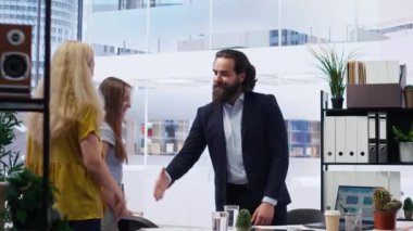 Mali ürünler ve yatırımlar tavsiye etmek ve onları karşılamak için müşterilerle yapılan mali danışman toplantısını memnuniyetle karşıladı. Yatırım stratejileri uzmanı müşterilerle el sıkışma yapıyor, kamera B