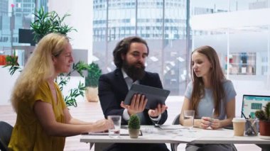 Finansal danışman finansal stratejiler sunuyor ve tablet kullanan müşterilere rehberlik ediyor. Ofisteki ajan, anne ve kızına yatırım portföyü yönetimi için yardım ediyor. Kamera A