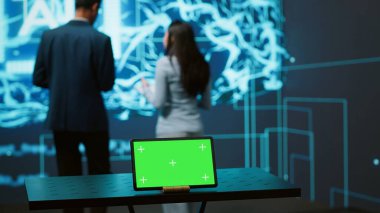 Yapay zeka programcıları iş veri analizi için yeşil ekran dizüstü bilgisayar kullanıyorlar. Yüksek teknoloji konum uzmanları, yapay zeka ve kamera A kullanarak görevleri otomatikleştirmek için kroma anahtar defteri üzerinde çalışırlar.