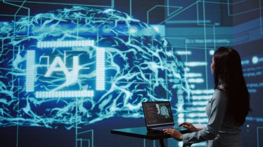 AI bilgisayar bilimcisi yüksek teknoloji çalışma alanında iş veri analizi için dizüstü bilgisayar kullanıyor. Hintli kadının yapay zeka ve kamera B kullanarak görevleri otomatikleştirmek için defter üzerinde çalışırken yakın plan görüntüsü.