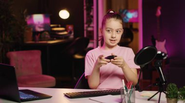 Çocuk içeriği yaratıcısı klavye incelemesini ev stüdyosunda kaydediyor. Daktilo yeteneğini göstermek için farklı düğmelere basıyor. Z jenerasyonunda izleyicilere bilgisayar kenarlarını gösteren küçük bir kız