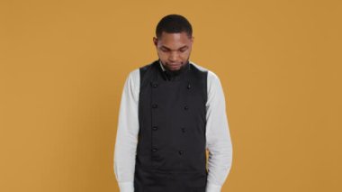 Profesyonel üniforma ve önlük giymiş garson portresi müşterilere yardım etmeye hazırlanıyor. Müşteri memnuniyeti için hizmet odaklı çevrede çalışan çalışanlar. Kamera B.