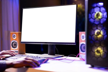 Man in dimly lit apartment playing video games on isolated screen gaming PC at computer desk, enjoying day off from work. Gamer battling enemies in online multiplayer shooter on mockup monitor clipart