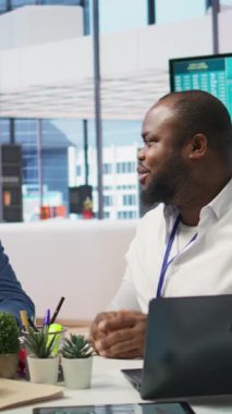 Dikey Video Üst Düzey Çifti, kapsamlı emeklilik planlarını tartışmak için modern bir ofiste profesyonel bir finans danışmanıyla görüşüyor. Hayat boyu tasarruf ve emeklilik seçenekleriyle yatırım planlama