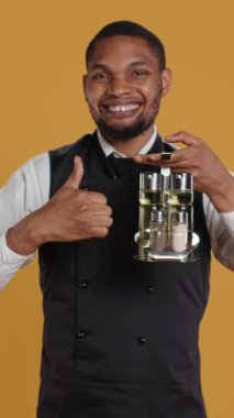 Dikey Video Becerikli Garson, kameranın önünde onayını ve stüdyoda olumlu duygularını gösteren bir işaret gösteriyor. Genç restoran çalışanları ya benzer ya da iyi bir işaret verir. Kamera B.
