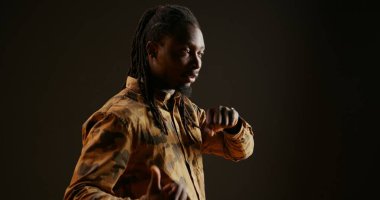 Akıllı telefon kullanarak sohbet eden, telefonlara cevap veren ve siyah arka planda uzaktan konuşma yapan havalı biri. Moda adamı modern kol saati ve telekomünikasyon seviyor..