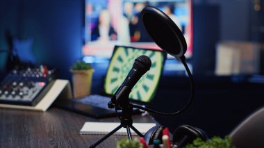 İnternet canlı yayın programındaki konuşmaları kaydetmek için kullanılan podcast mikrofonunun yakın çekim görüntüleri. Ses yakalama ve kaydetme teknolojisi boş ev stüdyosunda neon ışıkları ile