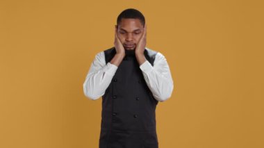 Restoran çalışanları onun gözlerini, ağzını ve kulaklarını kapatarak stüdyodaki kötülüğe karşı üç bilge maymun metaforu sunuyorlar. Garson konukseverlik endüstrisini ne görüyor, ne duyuyor, ne de konuşuyor. Kamera B.