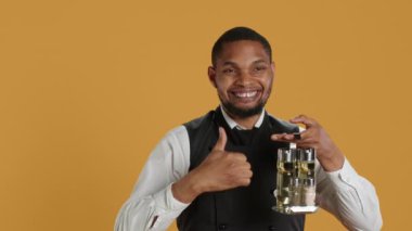 Becerikli garson kameranın önünde olumlu bir sembol gösteriyor, stüdyoda olumlu duygularını ve onayını sunuyor. Genç restoran çalışanları ya benzer ya da iyi bir işaret verir. Kamera A.