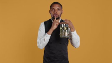 Garson, sessizlik ve mahremiyet için sessiz bir tabela hazırlıyor. Müşteri memnuniyeti için soslu sos taşırken sessizliğini koruyor. Sır tutmak için sessiz kalma sembolü gösterir. Kamera B.