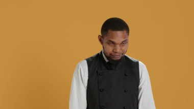 Profesyonel üniforma ve önlük giymiş garson portresi müşterilere yardım etmeye hazırlanıyor. Müşteri memnuniyeti için hizmet odaklı çevrede çalışan çalışanlar. Kamera A.