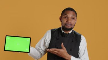 Yemek şirketi çalışanı önlük giyip müşterilerine servis yaparken izole bir kroma anahtar görüntüsü sunuyor. Profesyonel giyimli konukseverlik sektörü personeli, müşteri memnuniyeti. Kamera A.