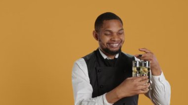 Gülümseyen dost canlısı garson, tuzluktan tuz döküyor, baharat taşıyor ve beş yıldızlı bir restoranda müşterilere servis yapıyor. Konukseverlik sektöründe yemek işçisi. Kamera A.