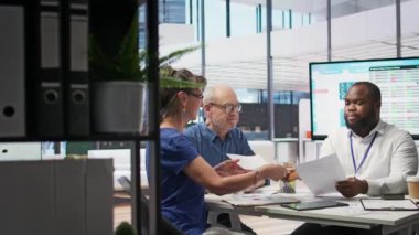 Finans danışmanı, gelecekteki tasarruf ve finansmanlarını güvence altına almak ve üst düzey müşterilerine uygun bir emeklilik planı konusunda yardım etmek için hesap makinesi kullanıyor. Gelirle ilgili mali tahminler. Kamera B.